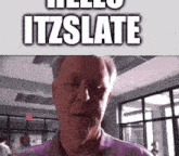 a man in a purple shirt is looking at the camera and says hello itzslate