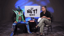 a man sits in front of a sign that says " hey "