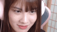 a close up of a girl wearing headphones and making a face .