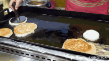 pancakes are being cooked on a griddle and the words made in animotica can be seen in the corner