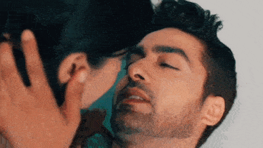 a man and a woman are kissing each other on the cheek .