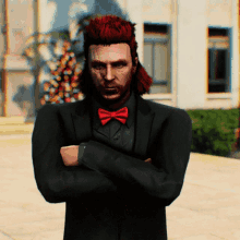 a man with red hair and a red bow tie is standing with his arms crossed