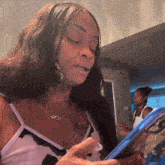 a woman with a tattoo on her chest is looking at a cell phone