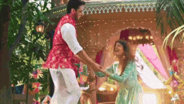 a man and a woman are dancing in front of a building .