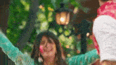 a man is holding a woman in his arms while she is covered in holi colors .
