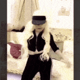 a woman wearing a hat and sunglasses is dancing