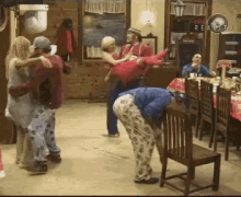 a group of people are dancing in a room with a sign that says ping realty
