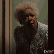 an older woman is standing in a doorway with showtime on the bottom right