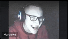 a man wearing headphones and glasses is smiling in the dark