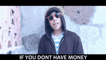 a man wearing a hoodie and sunglasses is standing in front of a stone wall and says if you dont have money
