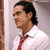 a man with curly hair wearing a white shirt and red tie with the name colucciyarango on the bottom right