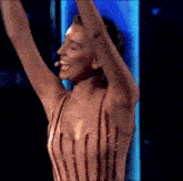 a woman in a striped dress has her arms in the air and is smiling