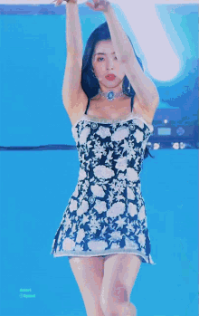 a woman in a black and white floral dress is standing in front of a blue background that says dupont