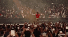 a man is singing into a microphone in front of a crowd of people