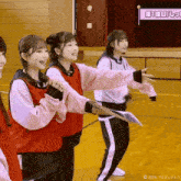 a group of girls are dancing in front of a sign that says " 第 1 回 "