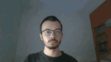 a man with glasses and a beard is making a face