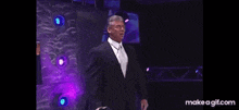 a man in a suit and tie is making a funny face in front of a microphone .