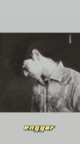 a shirtless man with a tattoo on his back is laying on a bed with the word enggaar written on the bottom