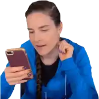 a woman in a blue jacket is looking at a cell phone