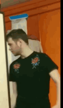 a man wearing a black shirt with roses on the shoulder