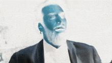 a man with a blue face is wearing a black suit