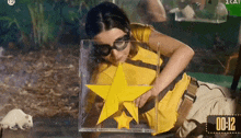 a woman in a yellow shirt is holding a yellow star in front of a timer that reads 00:12