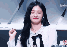a woman in a white shirt with a black tie and the number 124 on the bottom