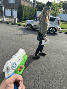 a person holding a water gun with a cross on the front
