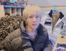 a person wearing a leopard print jacket is sitting in front of a desk