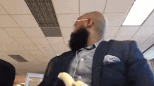 a man with a beard is holding a banana in his hand