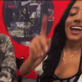 a woman with long black hair is giving a thumbs up sign