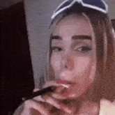 a woman is smoking an electronic cigarette in a dark room .