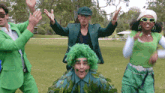 a group of people dressed in green are dancing