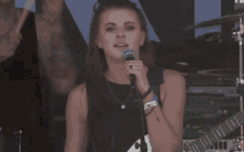 a woman is sitting on a man 's shoulders on a stage in front of a microphone .
