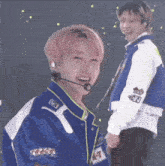 a man with pink hair is wearing a blue jacket that says track on it