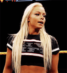 a blonde woman wearing a black and white crop top with the letters ecw on it