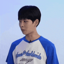 a man wearing a blue and white shirt that says ' true worldwide ' on it