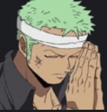 a man with green hair is wearing a headband and praying with his hands folded .