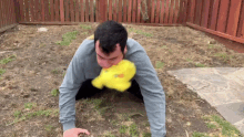 a man is playing with a stuffed duck in the dirt