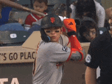 a baseball player getting ready to swing his bat with a sign that says ' go place ' in the background