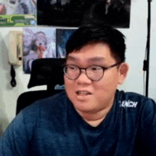 a man wearing glasses and a shirt that says launch on it