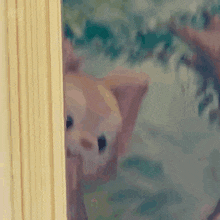 a close up of a stuffed animal peeking out from behind a door .