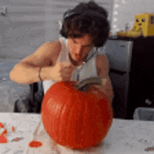 a man is carving a pumpkin with a knife on a table