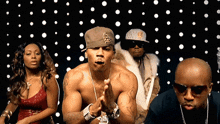 a man wearing a hat with the letter s on it stands in front of a group of people