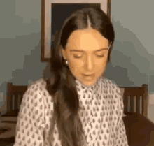 a woman with long hair is standing in front of a bed .