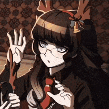 a girl with glasses and antlers on her head is waving her hand .