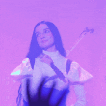a woman in a white shirt is holding a microphone in front of a pink background