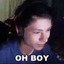 a man wearing headphones and a blue shirt is making a funny face and saying oh boy .