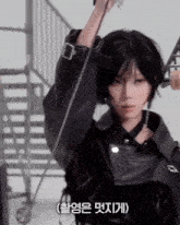a woman in a black leather jacket is holding a rope with chinese writing on it