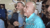 a group of men are dancing and one of them is wearing a blue shirt with arabic writing